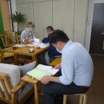 請負契約を進める横で銀行の担当者が準備をしている。ダブルヘッダーで契約