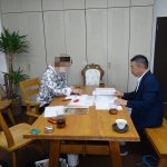 請負契約書に捺印する夫。妻は子どもをあやしに退席中